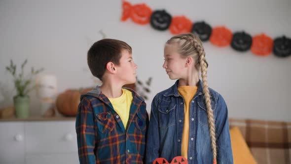 Portrait of Children During Halloween Girl and Boy with Masks in Form of Pumpkins Pose for Camera at