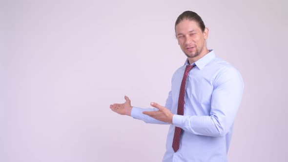 Happy Handsome Businessman Showing Something To the Back