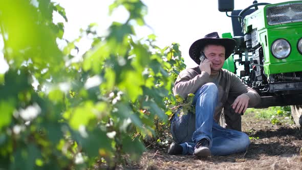 American Farming Field in Colorado USA He is Talking on a Smartphone