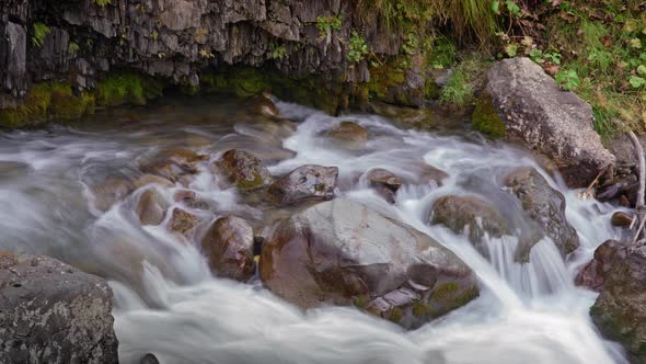 Timelapse of creek flows through stones