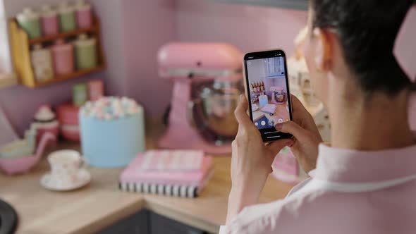 Pastry Chef Photographing a Corner in her Bakery Candy Shop using a Smartphone, Slow Motion, Closeup