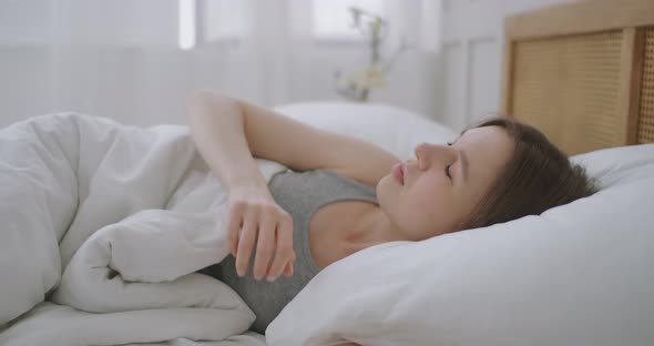 Young Woman Laying in Bed Suffers From Noise Generated By the Construction Site Outside the Window