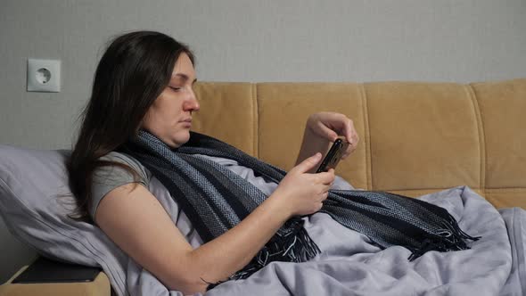 Sick Woman Sits on Sofa and Orders Medicine Via Smartphone