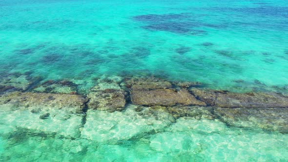 Beautiful drone tourism shot of a paradise sunny white sand beach and aqua turquoise water backgroun