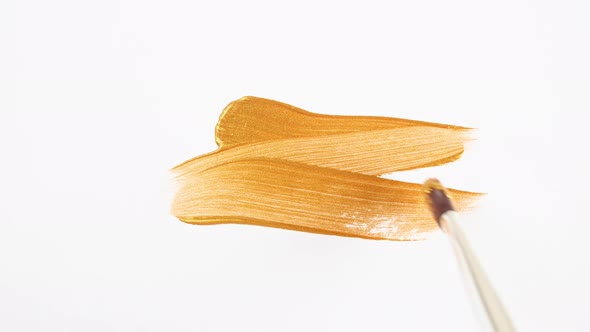 Abstract Brushstrokes of Gold Paint Brush Applied Isolated on a White Background