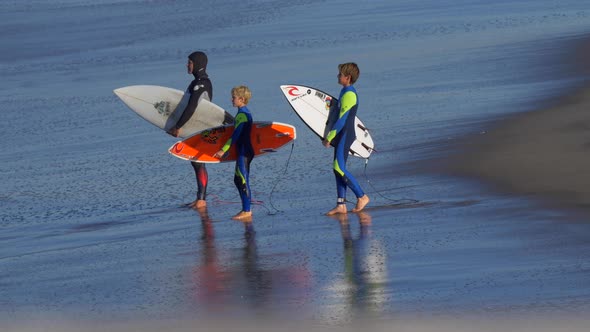 Some youth surfer boys get ready to go surfing.