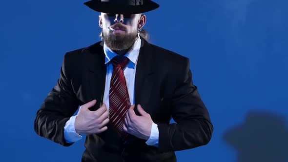 Elegant Man in a Black Hat Is Dancing an Erotic Dance. Spotlight on a Blue Background. Close Up