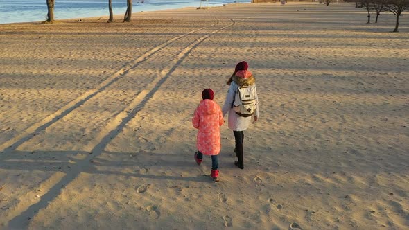 Mother With Daughter Walking By The Beach