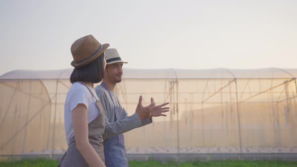 Happy two Asian couple farmers owner working and walk in vegetables hydroponic farm with happiness