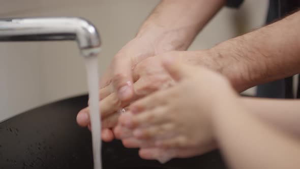 Unrecognizable Man and Boy Washing Hands