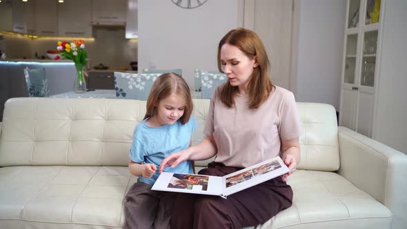 Mother and Daughter Looking a Book with Photos From a Family Photo Shoot