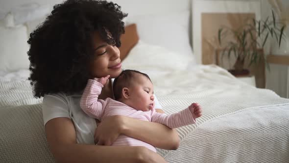 Family of Mom and Baby Girl Having Good Time Together and Sitting on Bed in Home Bedroom Spbd