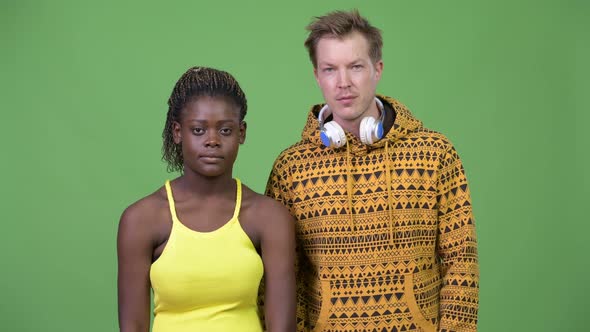 Young Multi-ethnic Couple Giving Thumbs Up Together