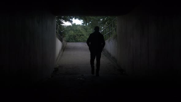 Silhouette Of Adult Male Entering Dark Tunnel Underpass. Locked Off