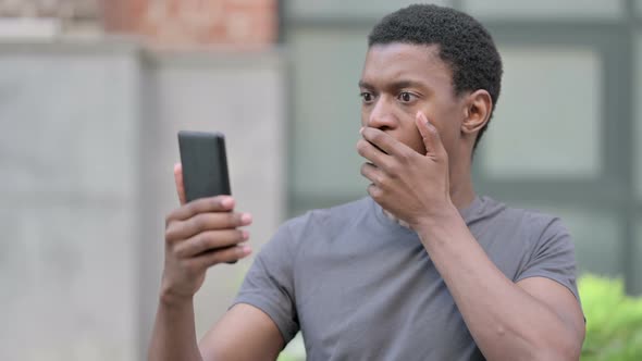 Portrait of Upset Young African Man Having Loss on Smartphone 