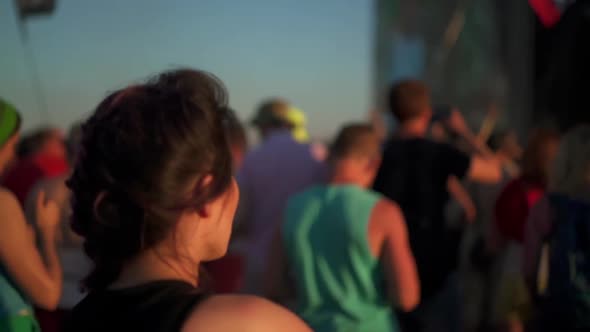 Rear View of Asian Woman Dancing Among the Crowd of People at Rock Concert Festival. Music Fans