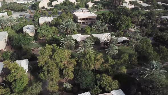 Aerial drone shot flying above a kibbutz community in the Israel desert