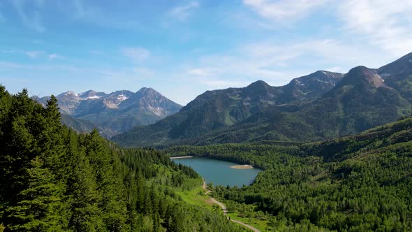 View of a picturesque lake in the Rocky Mountains then pull back between the pine trees
