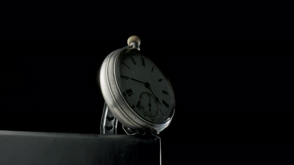 Silver Antique Pocket Watch on a Stand Rotating on a Black Isolated Background