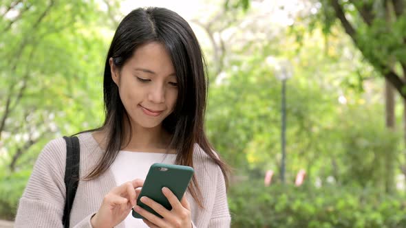 Woman taking out cellphone from bag and talking on mobile phone