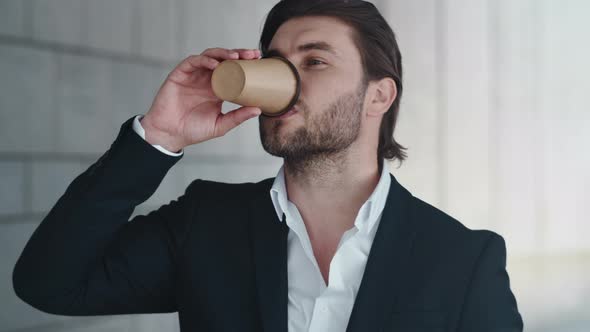 Businessman Drinking Take Away Coffee on Street. Male Entrepreneur Taking Break