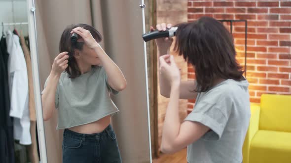 In the Room the Woman Holds a Haircut Machine and Begins to Shave Hair Bald Looking in Mirror