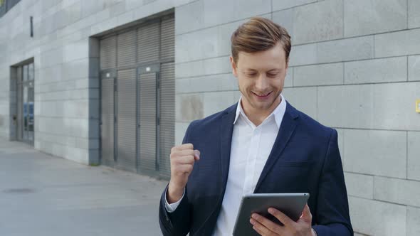 Businessman Using Digital Tablet at Street. Worker Celebrating Victory Outside