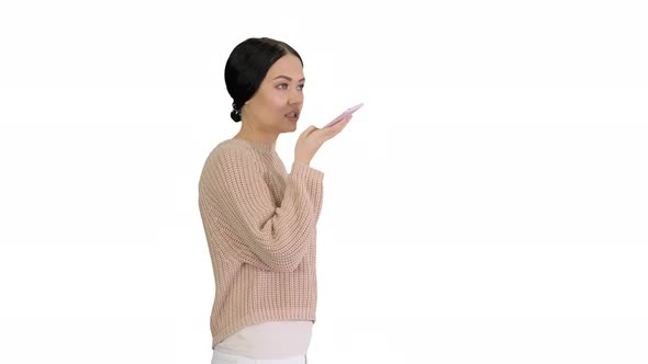 Young Woman Talking on the Phone Holding It To Her Face While Walking on White Background