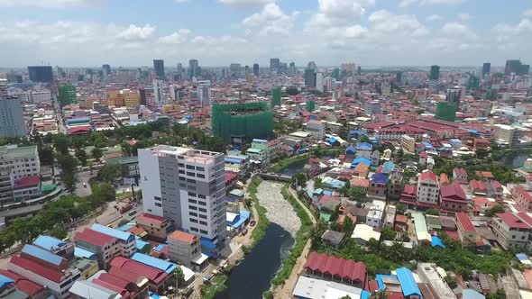 Aerial view of polluted river crossing city, Cambodia.