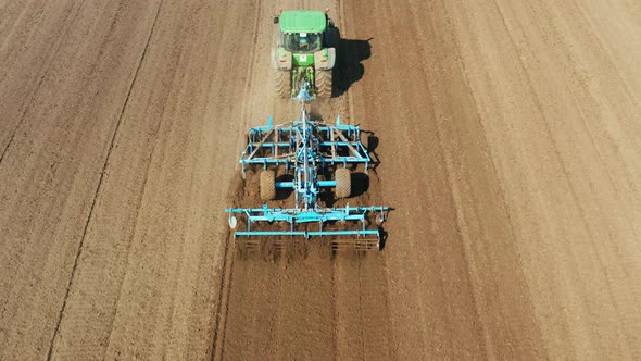 Tractor with Disc Harrows on the Farmland