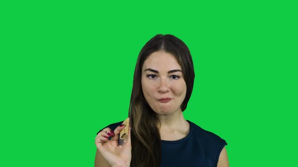 Sexy attractive girl eating a biscuit in front of a green screen