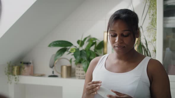 African-American woman feeling fresh after applying roll on antiperspirant. Shot with RED helium cam