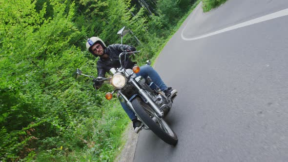 Man riding a motorcycle on a forest road