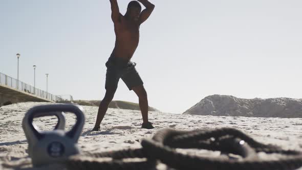 African american man working out with a medicine ball at the beach