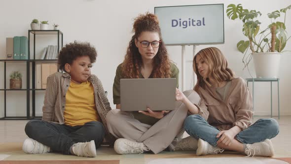 Woman and Kids Using Computer on Floor