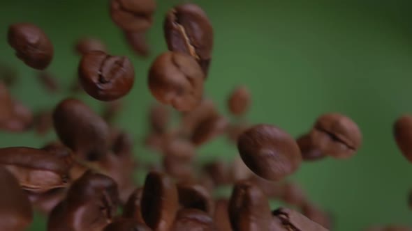 Closeup of Arabica Coffee Beans Flying Diagonally on the Olive Green Background