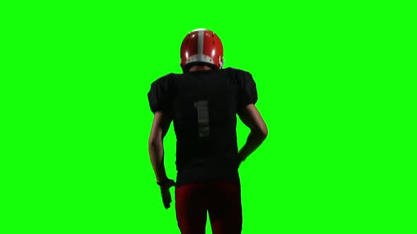 Football Player Running with the Ball and Throws It To the Side. Green Screen, Back View