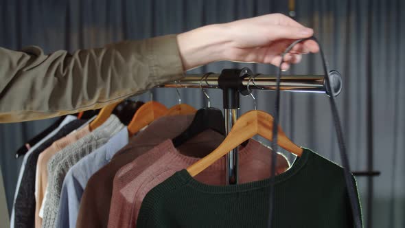 Close Up of Woman Hangs a Bag on a Hanger with Clothes