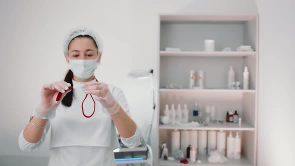 A Nurse Holding a Tourniquet Before Pulling Blood