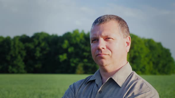 A Man Is Standing in a Field, Looking Into the Distance