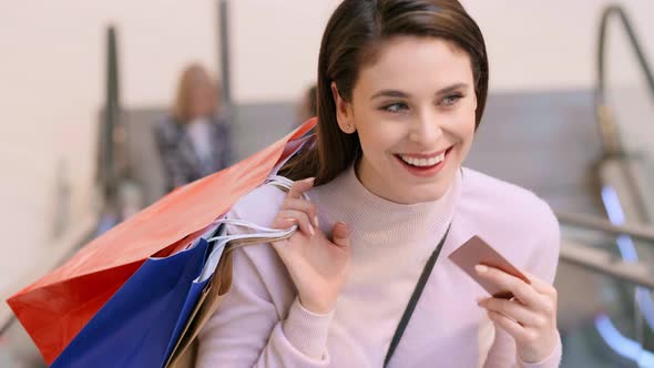 Woman with credit card and shopping bags during big shopping