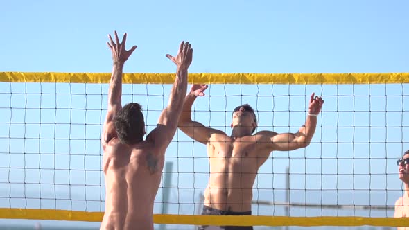 Men playing beach volleyball.