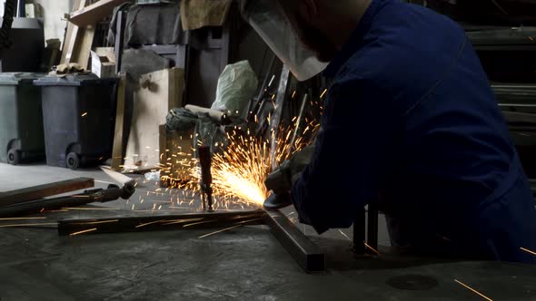 Anonymous workman welding metal construction in workshop