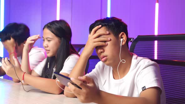 Team Of Asian Gamers Playing In Competitive Video Games By Mobile Phone And Lose The Game