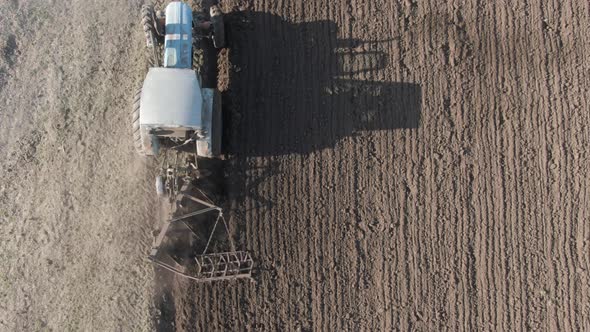 Camera Follows Tractor Furrowing Soil