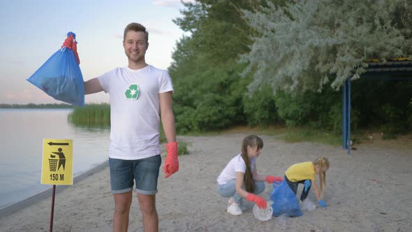 Environmental Protection, Portrait of Happy Volunteer Male in Rubber Gloves with Garbage Bag Near