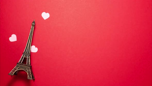 The Eiffel Tower, pink small hearts on red background. Stop motion animation with copy space alt
