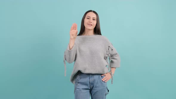 Bored Woman Make Blah Blah Gesture with Hand Isolated on Turquoise Background