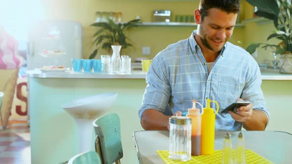 Man using mobile phone while having coffee 4k