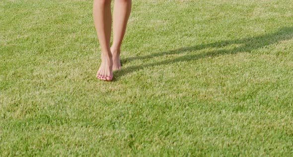 Close Up of Woman Walking on Lawn with Barefoot